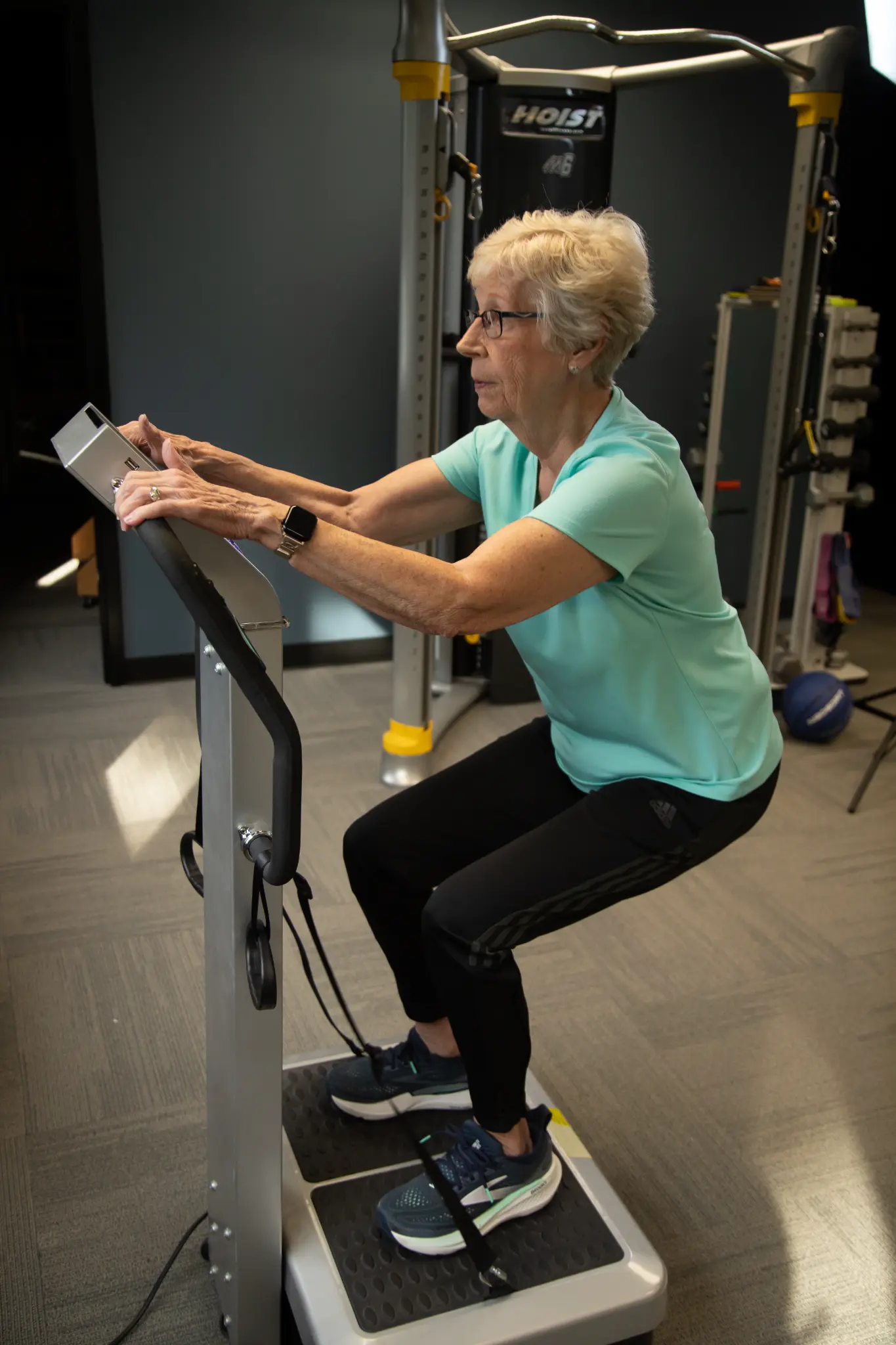 Client using a Whole Body Vibration platform during an active-aging fitness session at MARC